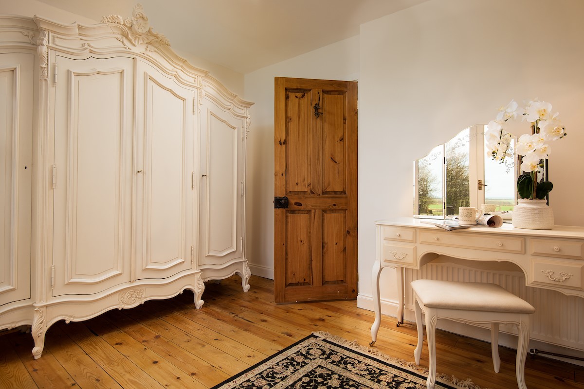 Castle View Cottage - a large freestanding wardrobe and dressing table complete bedroom one