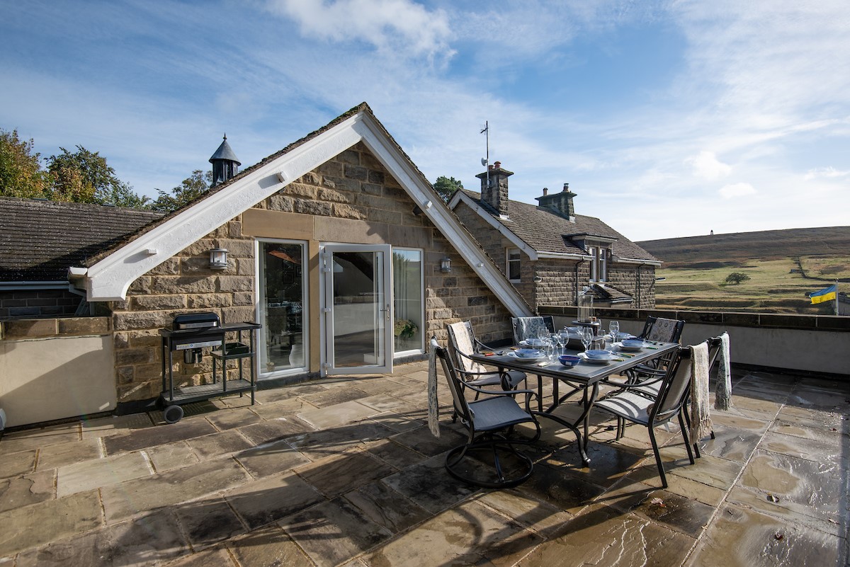 Roundhill Coach House - the large stone flagged terrace area with gas BBQ