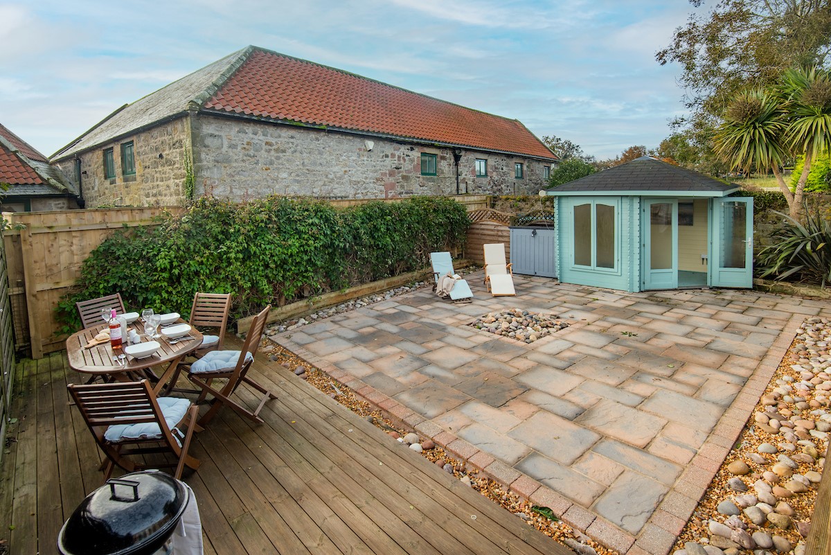 Friars Farm Cottage - sunny south-facing deck with garden furniture leading down to the large patio with sun loungers