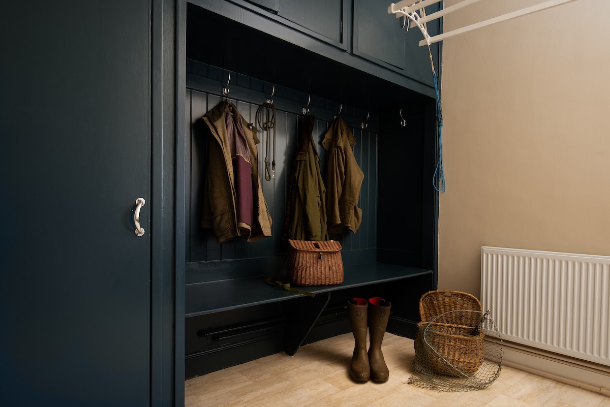 Wark Farmhouse - the boot room with bench seating and hanging space for outdoor kit