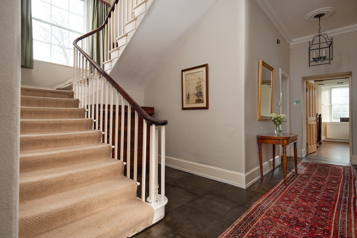 The Old Vicarage - hallway with sweeping staircase leading to the upper floors