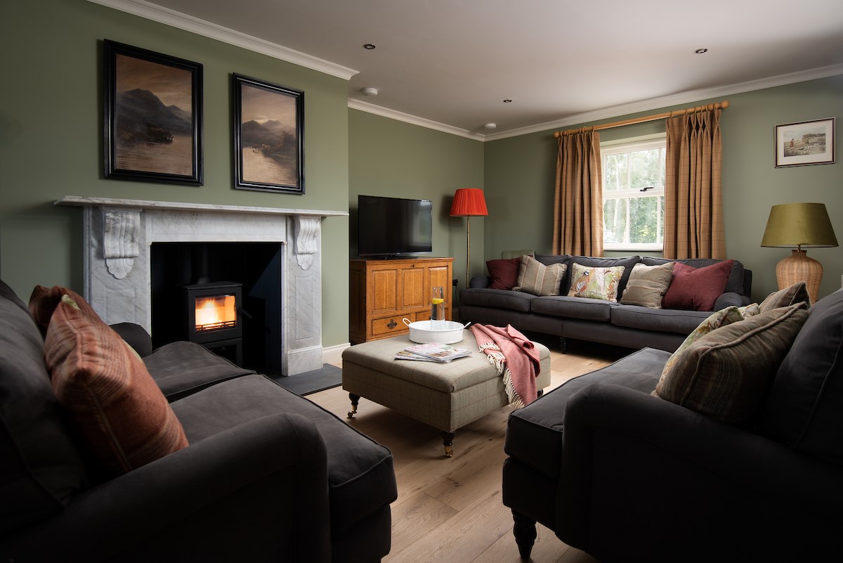 Risingham House - sitting room with comfortable seating in front of a log burner