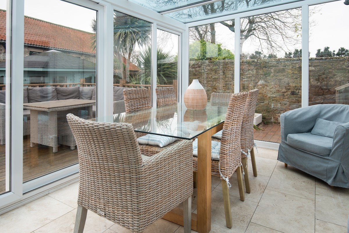Friars Farm Cottage - glass dining table with 6 chairs where guests can enjoy meals with views of the garden