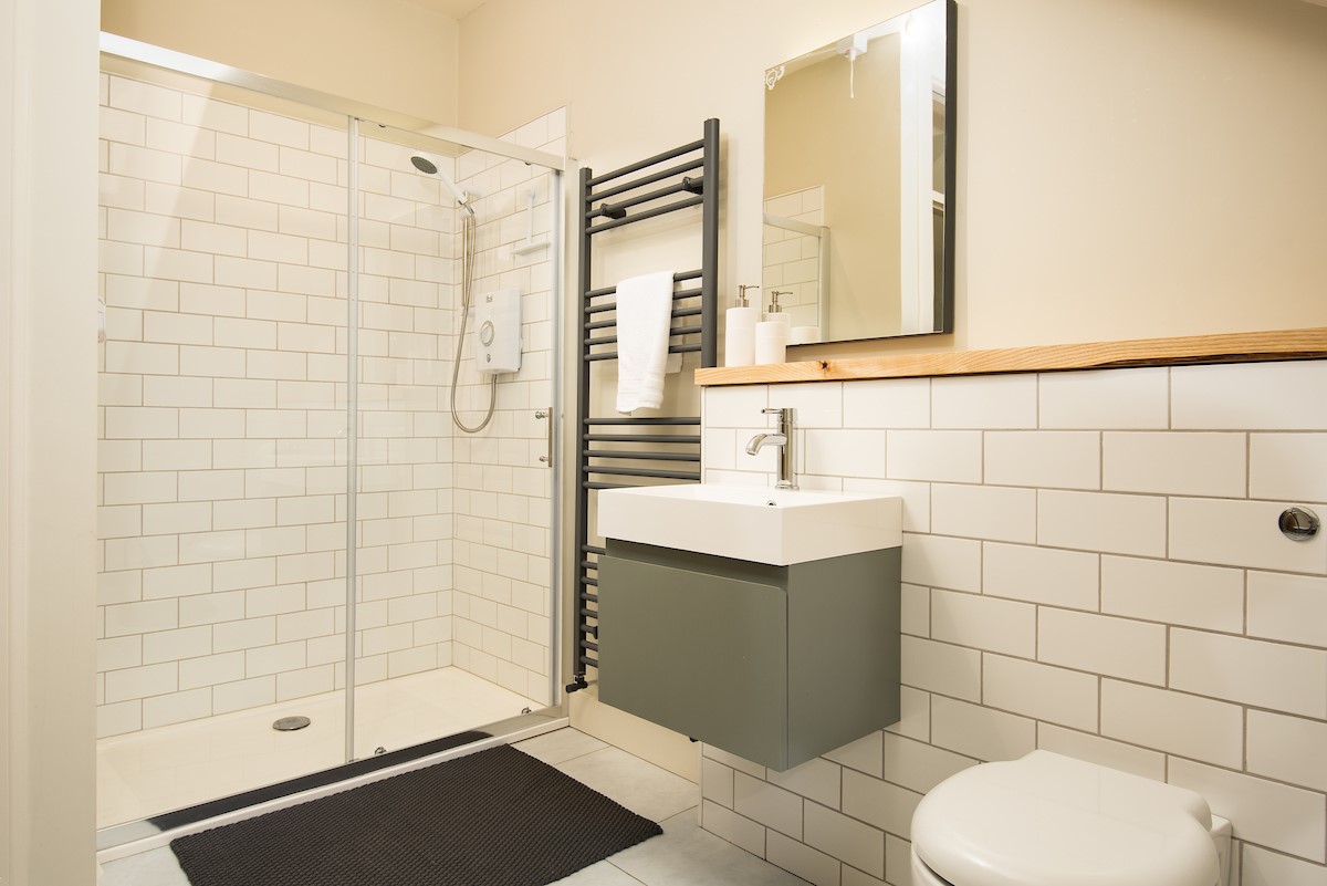 Trouthouse - large walk-in shower in the main bathroom with heated towel rail and wall-hung basin