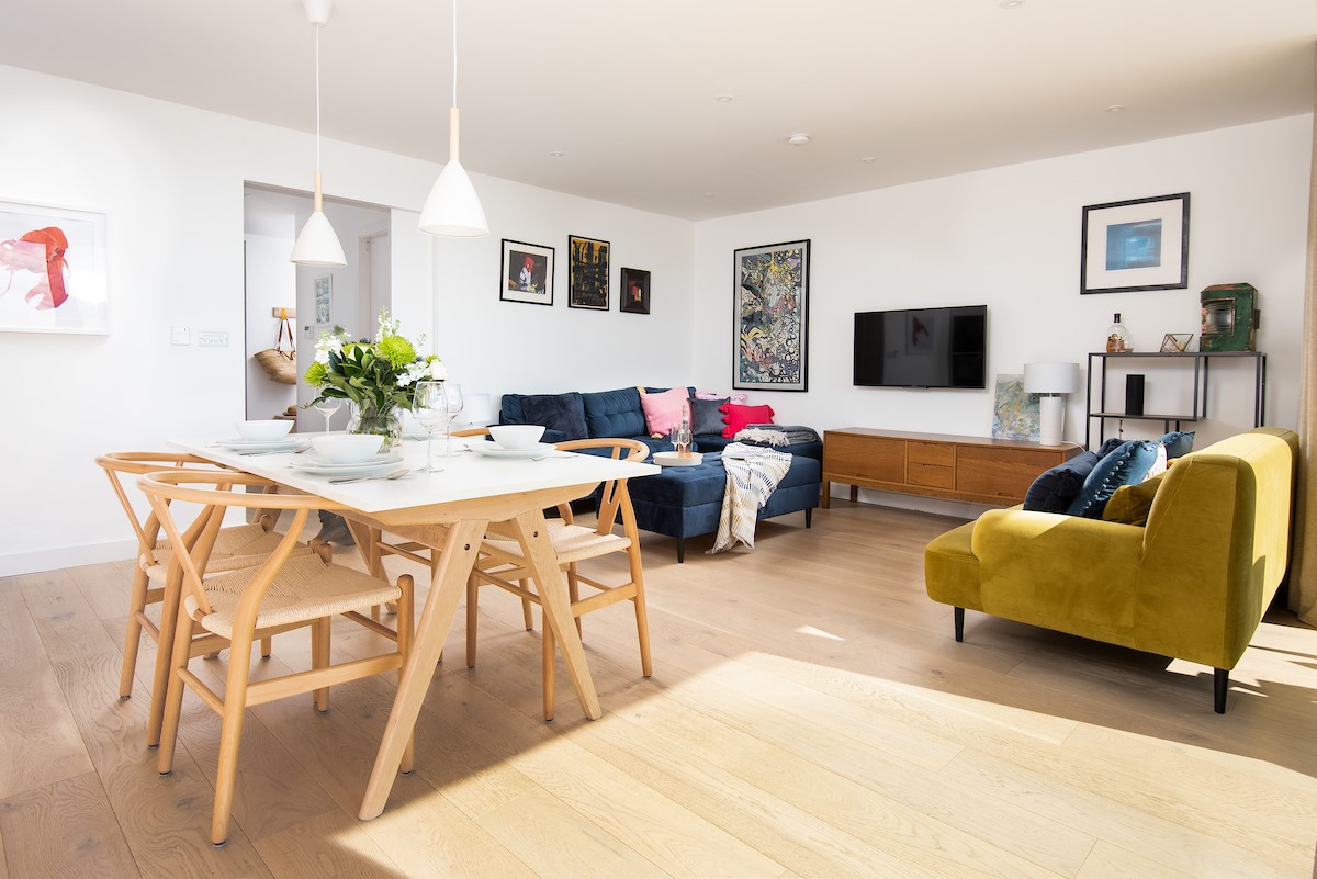 7 The Bay, Coldingham - open-plan living space with plush colourful sofas and dining space for four