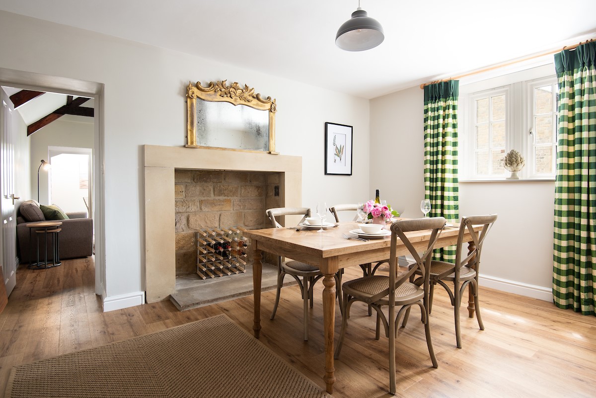 East End Cottage - the dining room with a decorative feature fireplace, leads into the sitting room