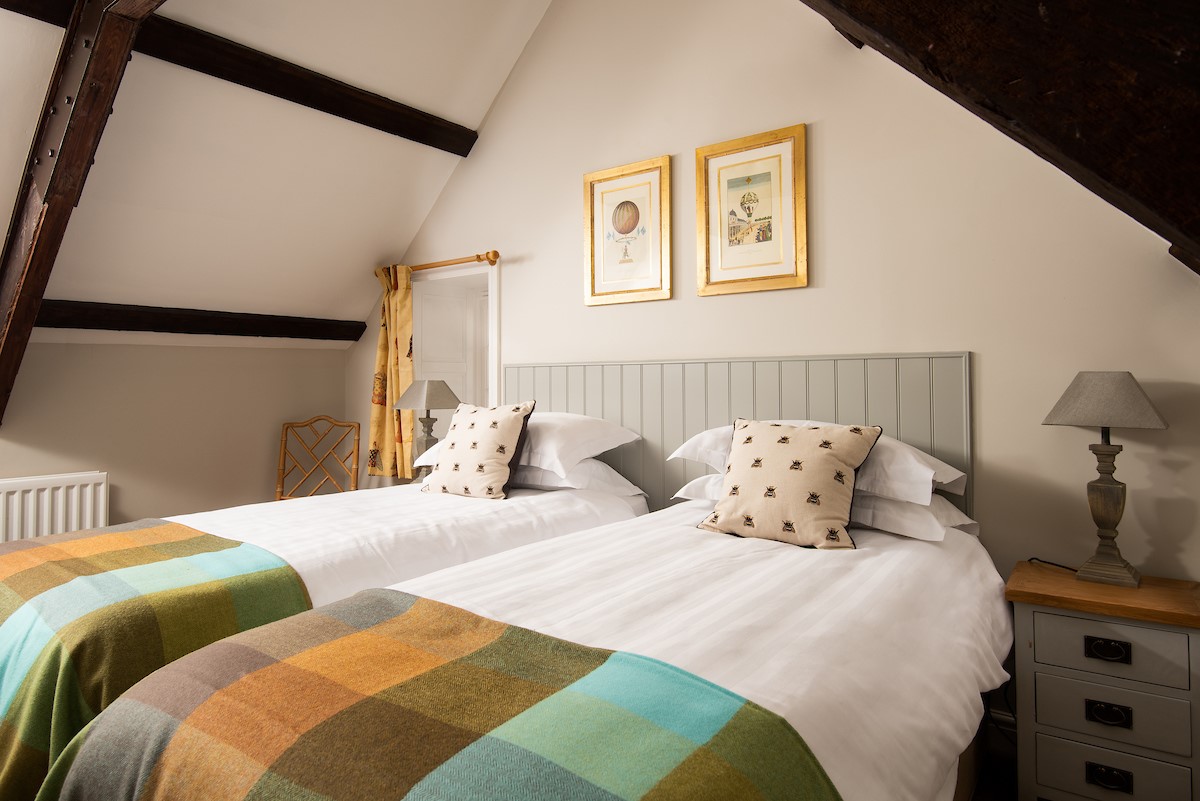 East End Cottage - bedroom two with coombed ceiling and original oak beams