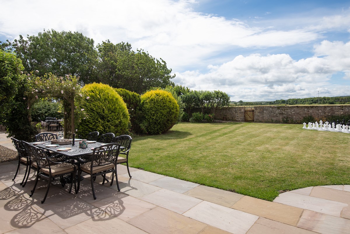 Brockmill Farmhouse - outdoor dining area looking across the enclosed lawned garden