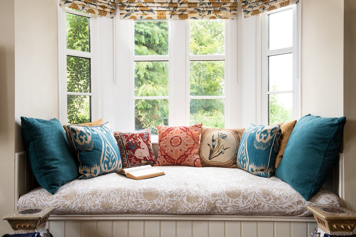 Rowchester West Lodge - comfy window seat set beneath the bay window - the ideal reading nook