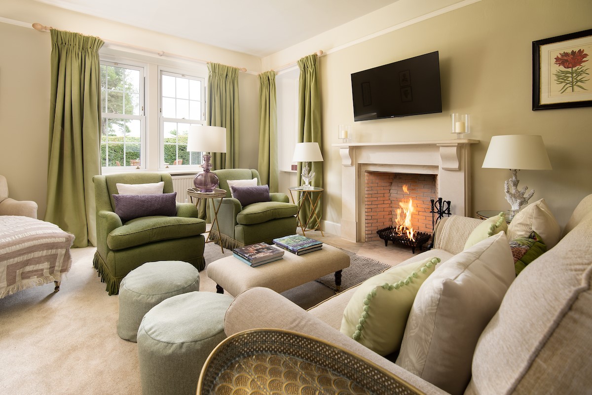 Lane Cottage - the beautiful touches of sage green in the lounge with an open fire at its centre