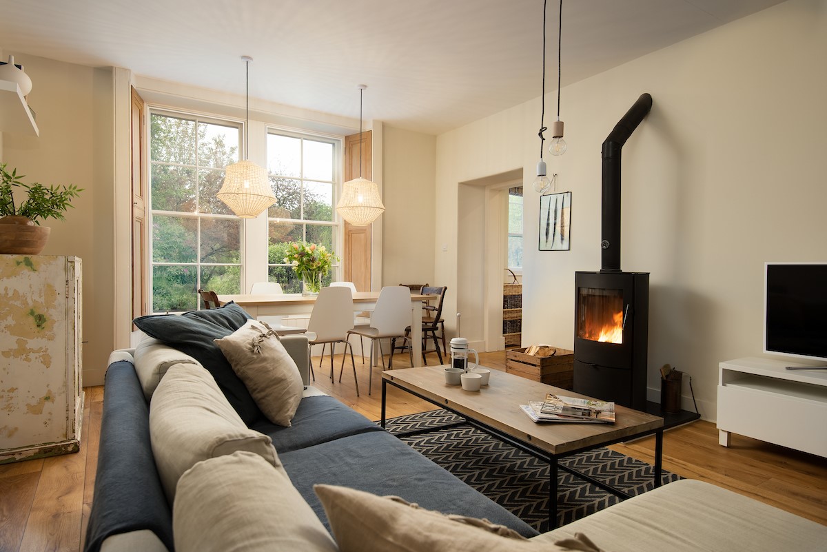 Trouthouse - relaxed sitting room and dining space with a modern log burner and feature pendant lighting