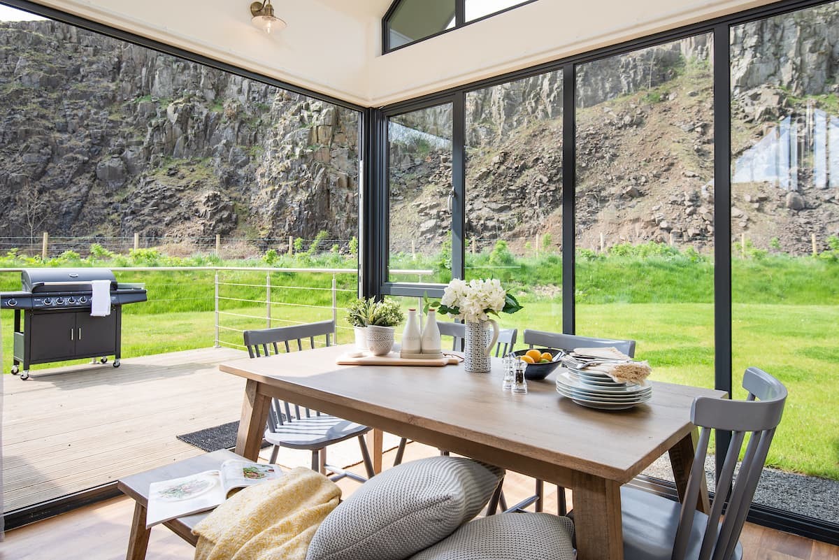 Oat Grass Lodge - the dining area with large bi-folding doors opening onto the patio area  (please note - a charcoal barbecue is now provided instead of the gas barbecue pictured)