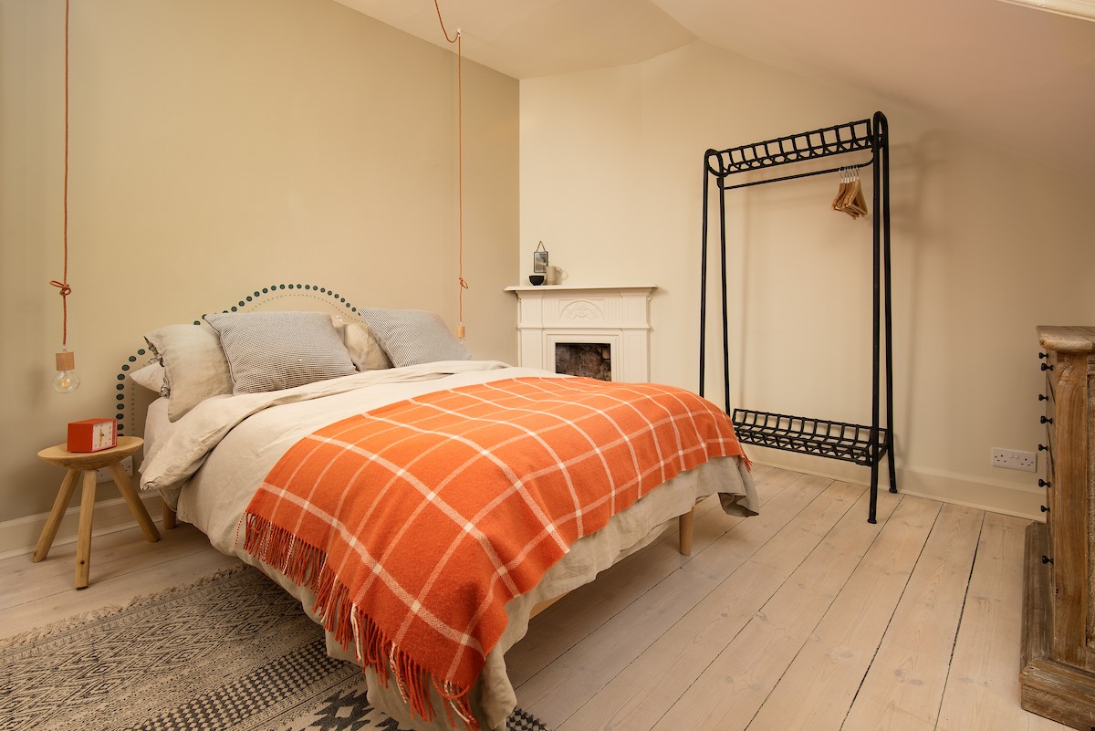 Trouthouse - bedroom two features a double bed with high quality linen sheets, Scandi-style open hanging rack and feature bedside lights