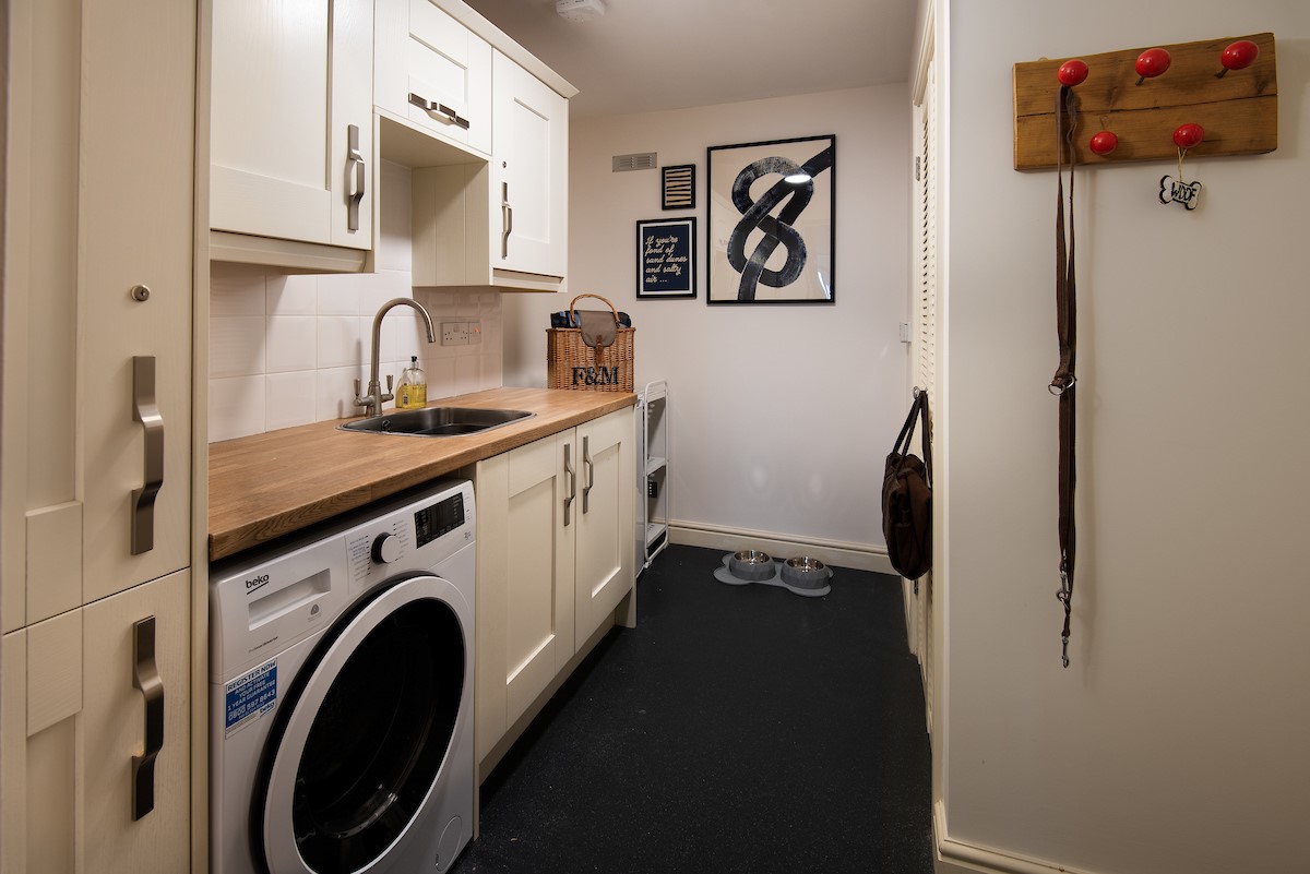 No. 6 - utility room leading to the rear garden with combi washer/dryer, basin and storage space
