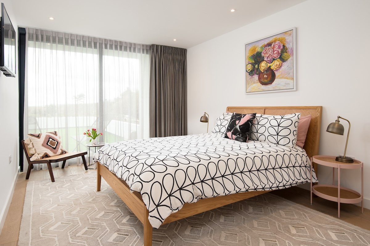 1 The Bay, Coldingham - bedroom one with king size bed and statement chair