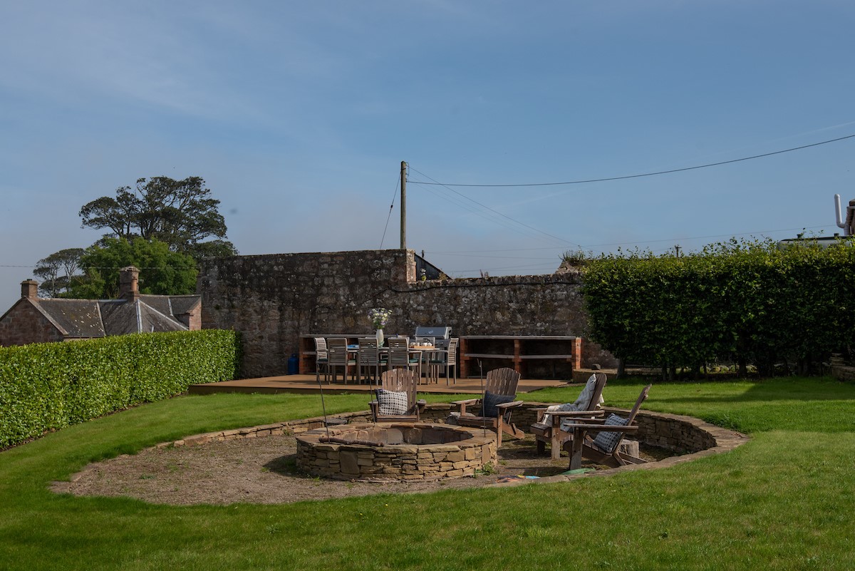Seaview House - sunken firepit area with outdoor seating and raised decking to the rear