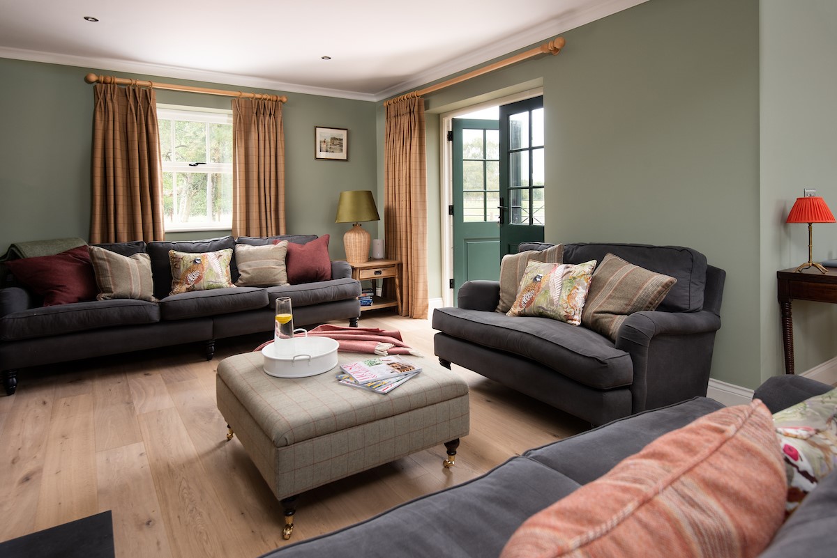Risingham House - sitting room with patio doors leading outside