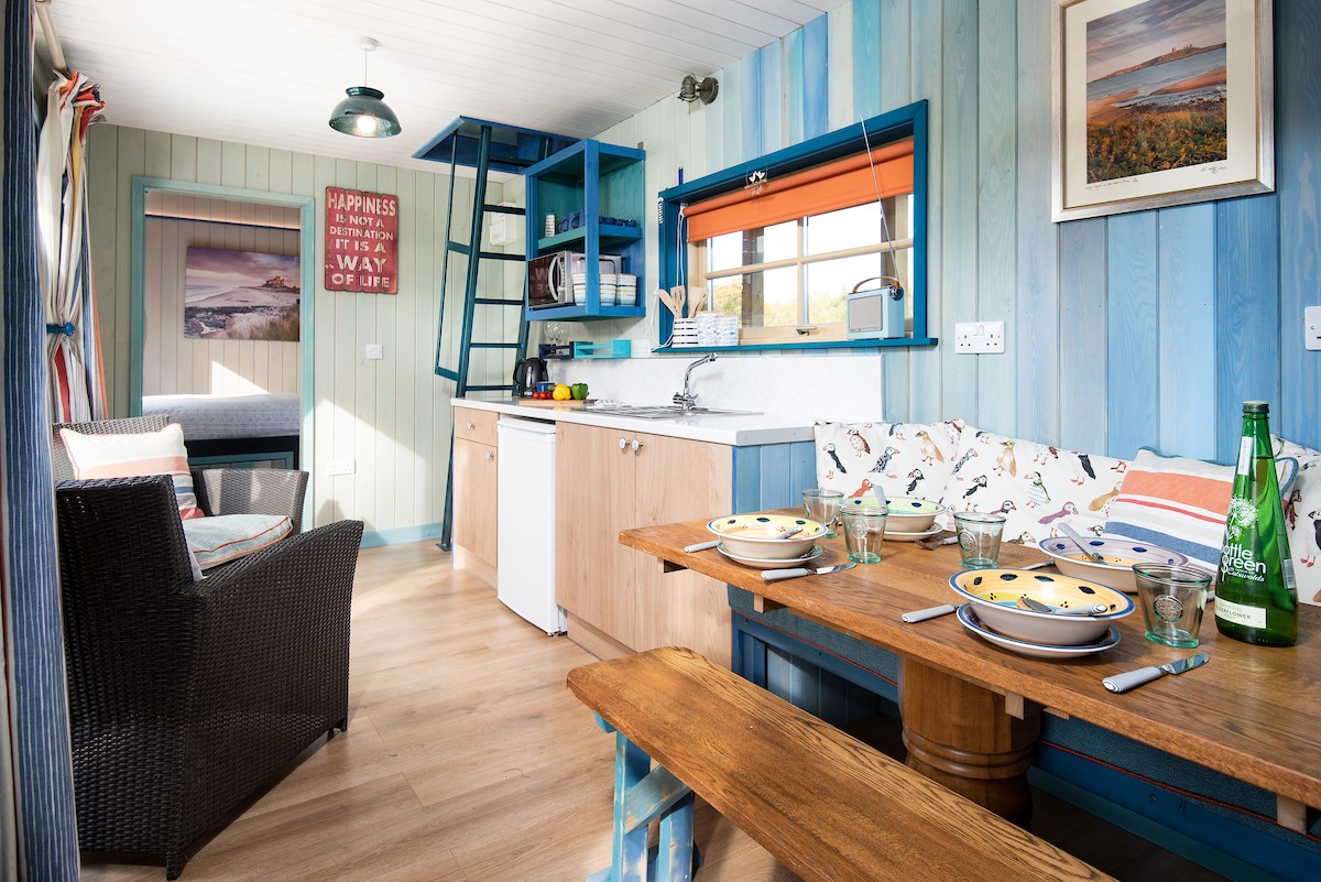 Berrington Beach Hut - dining area with bench seating