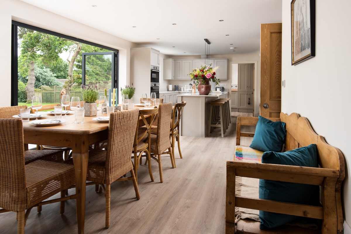Partridge Lodge - the convivial open plan kitchen dining area with large bi-fold doors to the terrace and garden areas