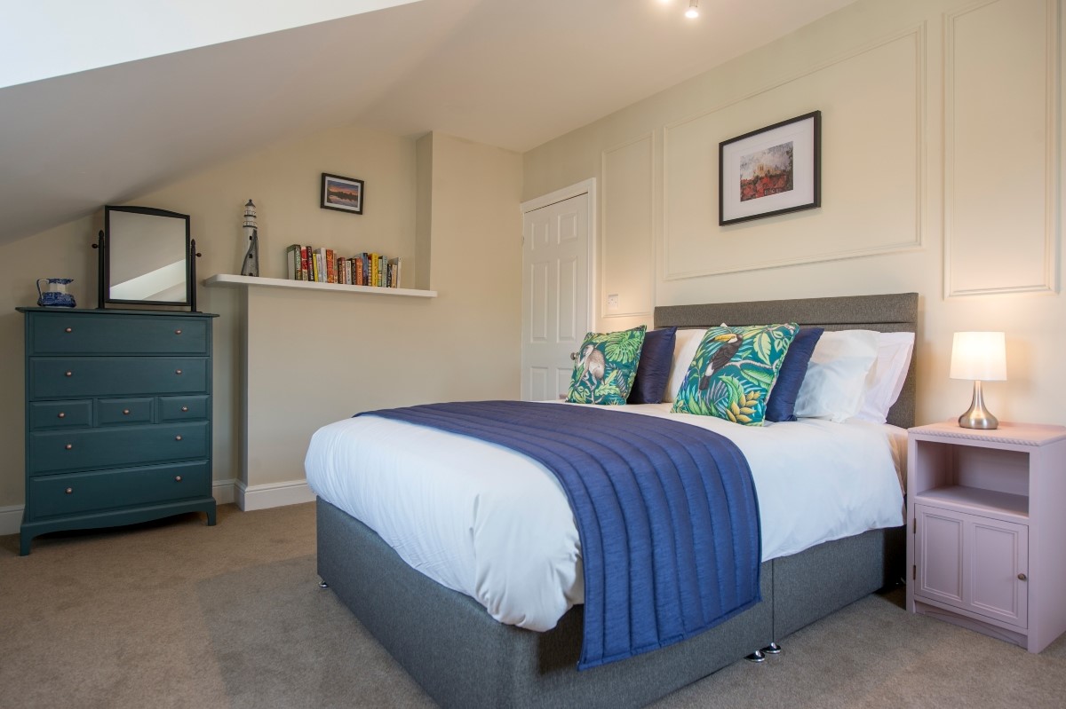 Spencer on the Lane - bedroom two with a double bed, large chest of drawers and wardrobe