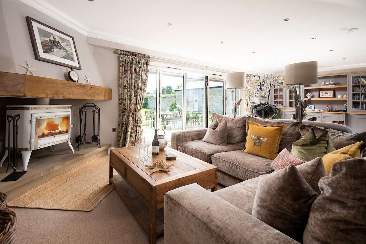 North Star House - sitting room with comfortable seating and cosy wood burner