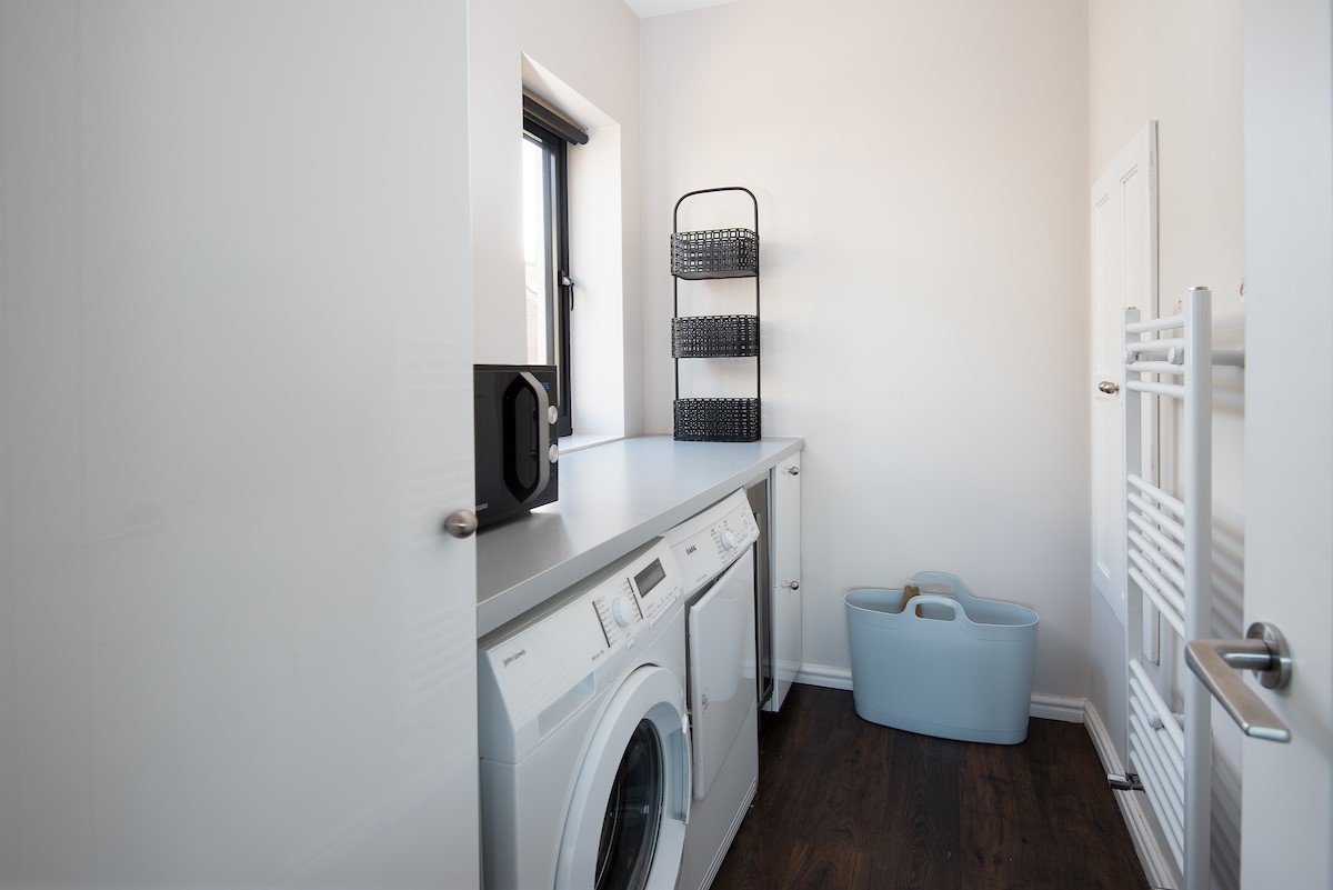 Duneside House - utility room with microwave, washing machine and tumble dryer