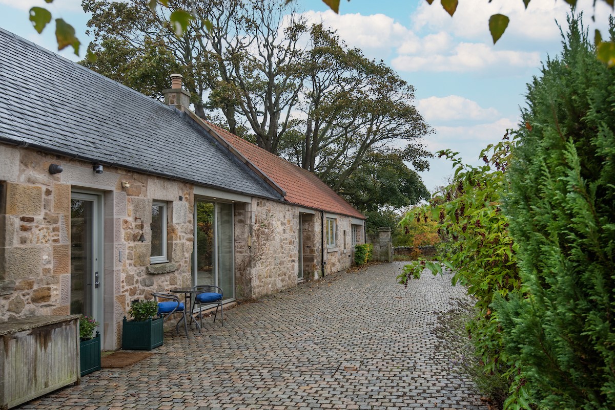 The Stables, Saltcoats Steading - cobbled courtyard with outdoor seating