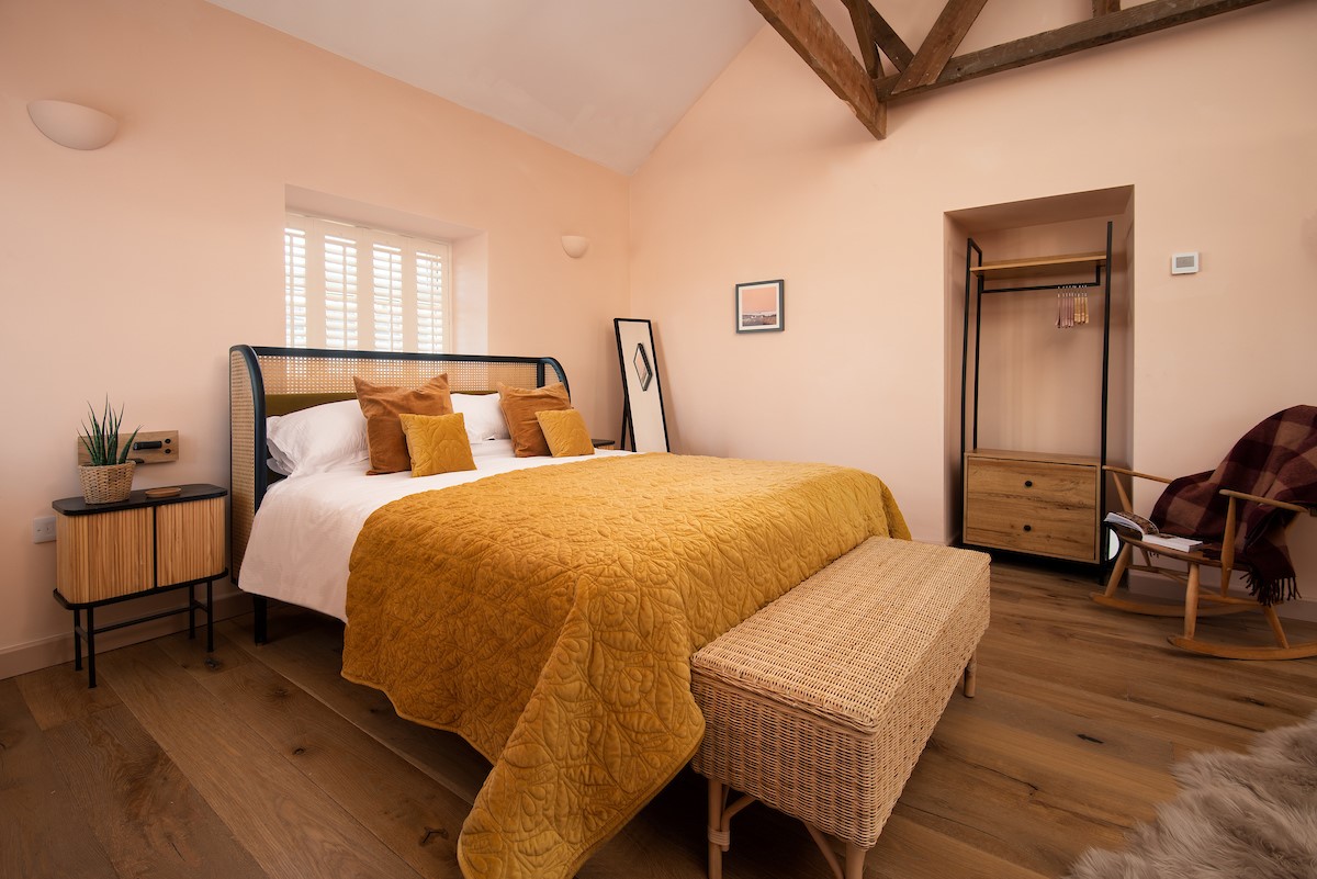 East Lodge Home Farm - bedroom one, with king size bed, bedside tables and chest of drawers with hanging rail
