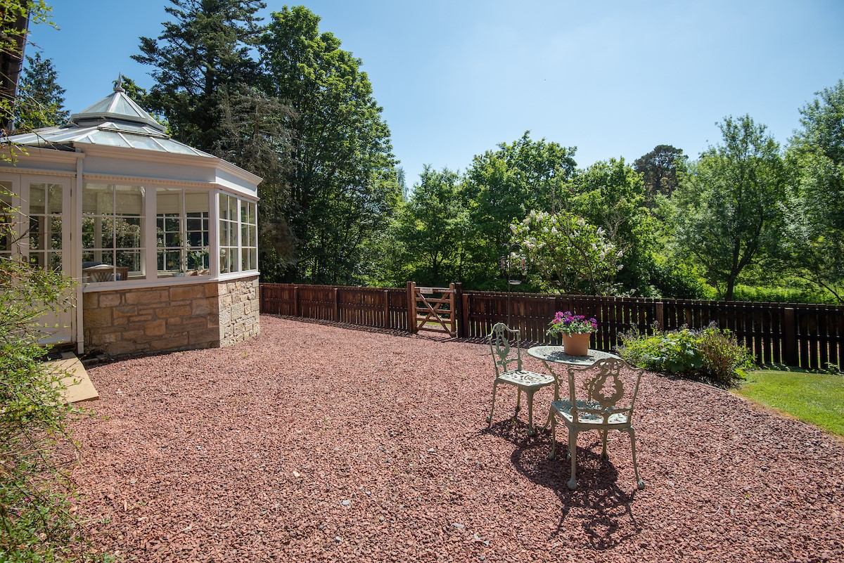 Eslington Lodge - gravel patio with small outdoor table