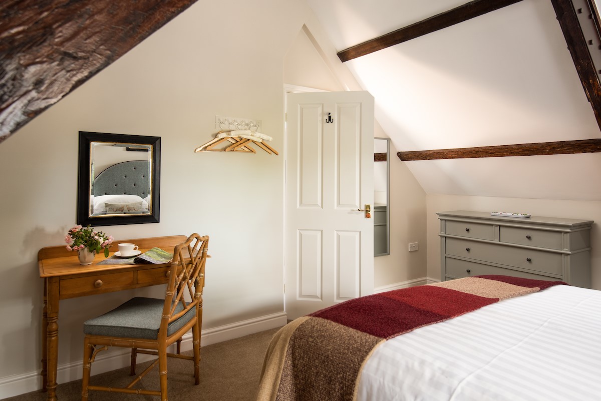 East End Cottage - bedroom one with dressing table and characterful beams