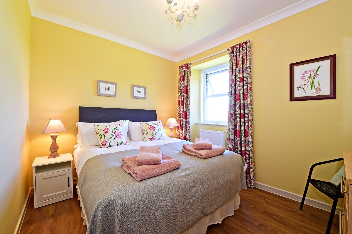 Fordel Cottage - bedroom one with king size bed, chest of drawers and single chair