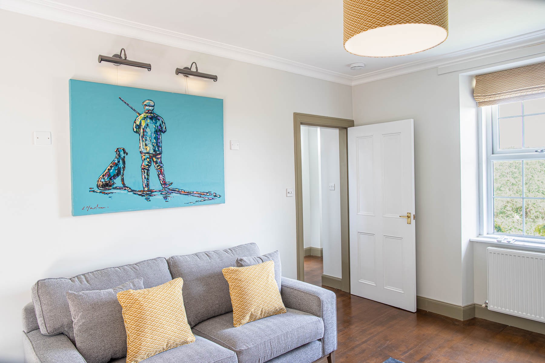 Culdoach Cottage - comfortable seating with bold artwork in the sitting room