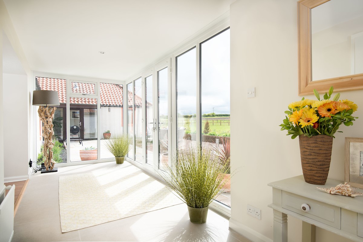 Westwood Cottage - sunroom with full-height patio doors and windows allow the light to beam in