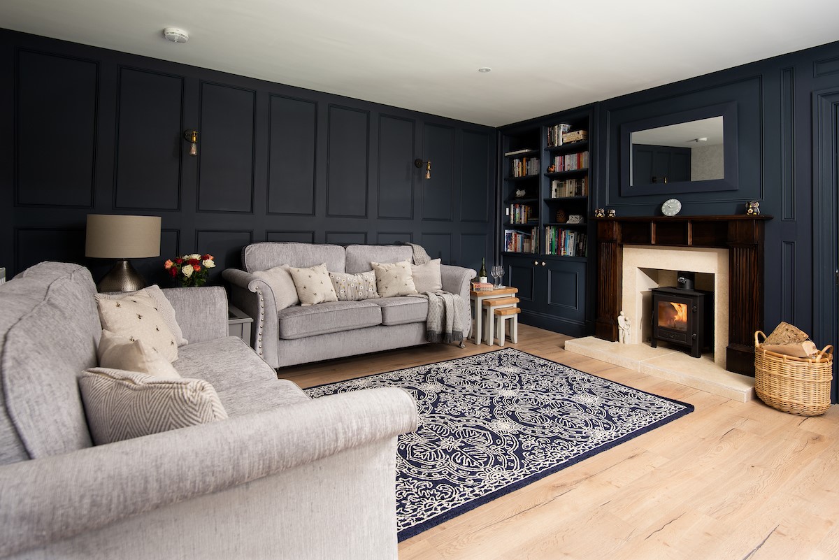 West Mill Cottage - sitting room with midnight blue panelled walls and large plush sofas