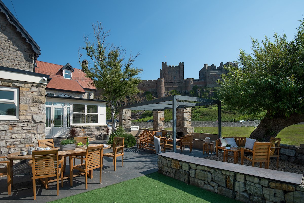 Castle View, Bamburgh - the enclosed garden with plenty of outside seating and stunning views of Bamburgh Castle