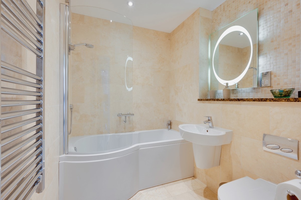 Skyfall - family bathroom with shower over P-shaped bath, heated towel rail, WC and basin