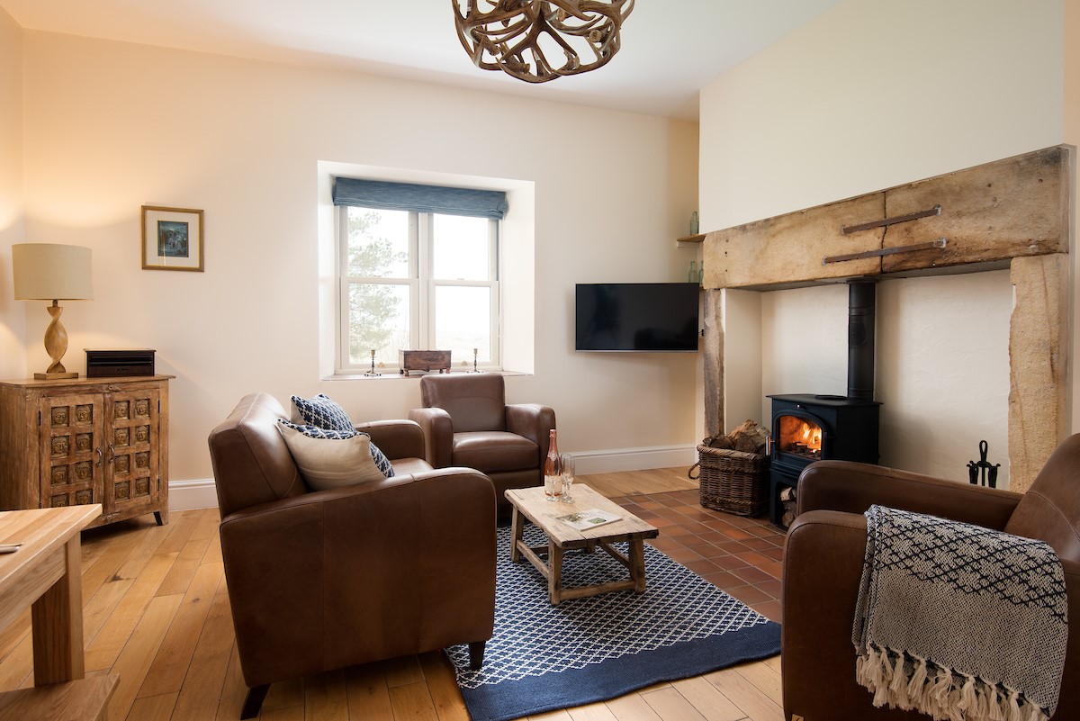 Tutor's Lodge - the old stone fire surround brings character to this warm living space