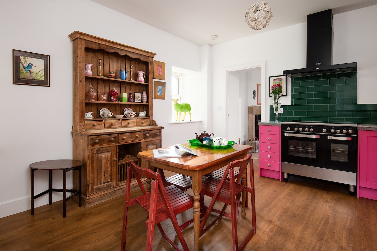 Walltown Farm Cottage - kitchen dining table with 4 chairs and vintage sideboard and dresser beyond