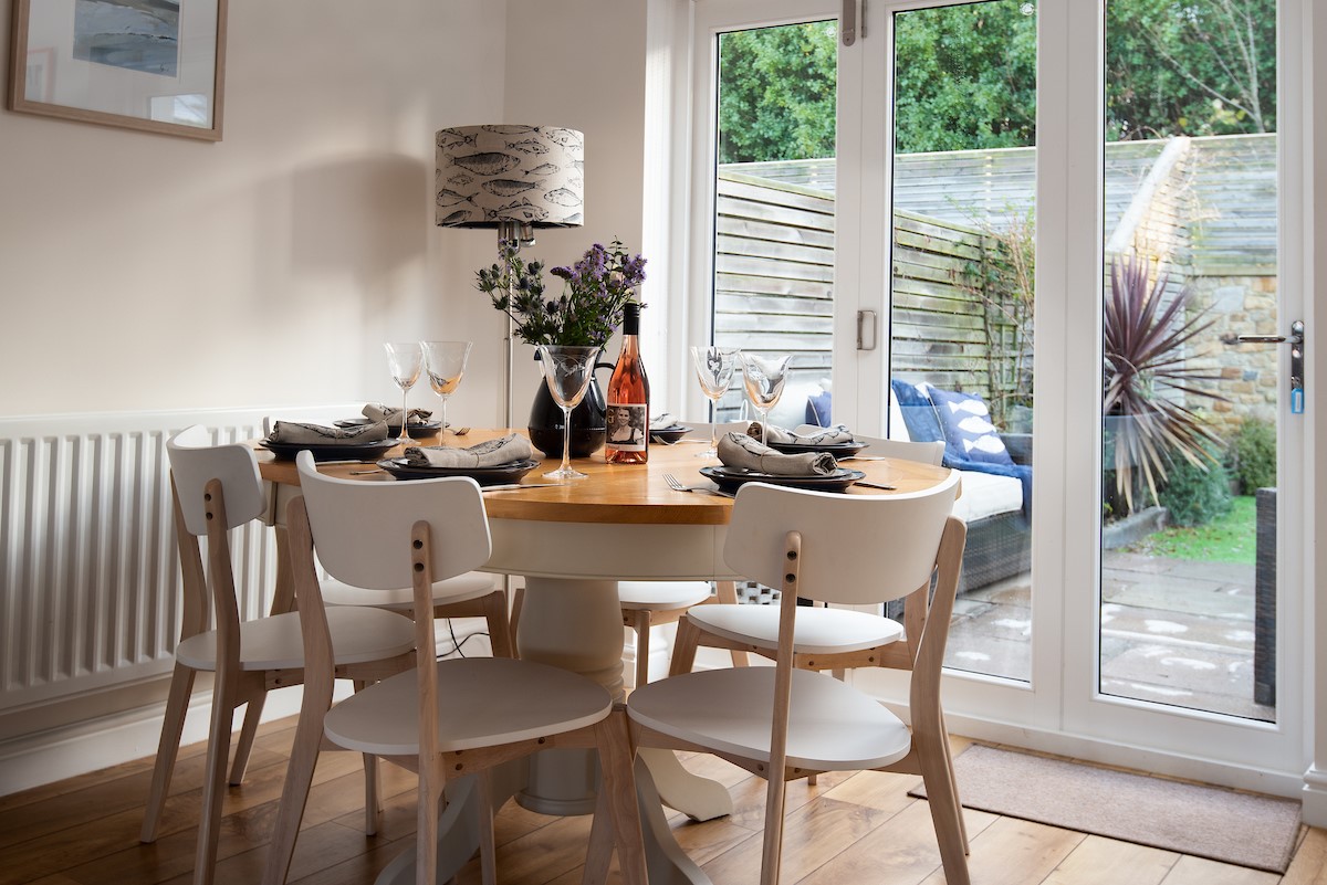 No. 6 - dining table situated in front of bi-folding doors offering views of the garden while guests enjoy their meals
