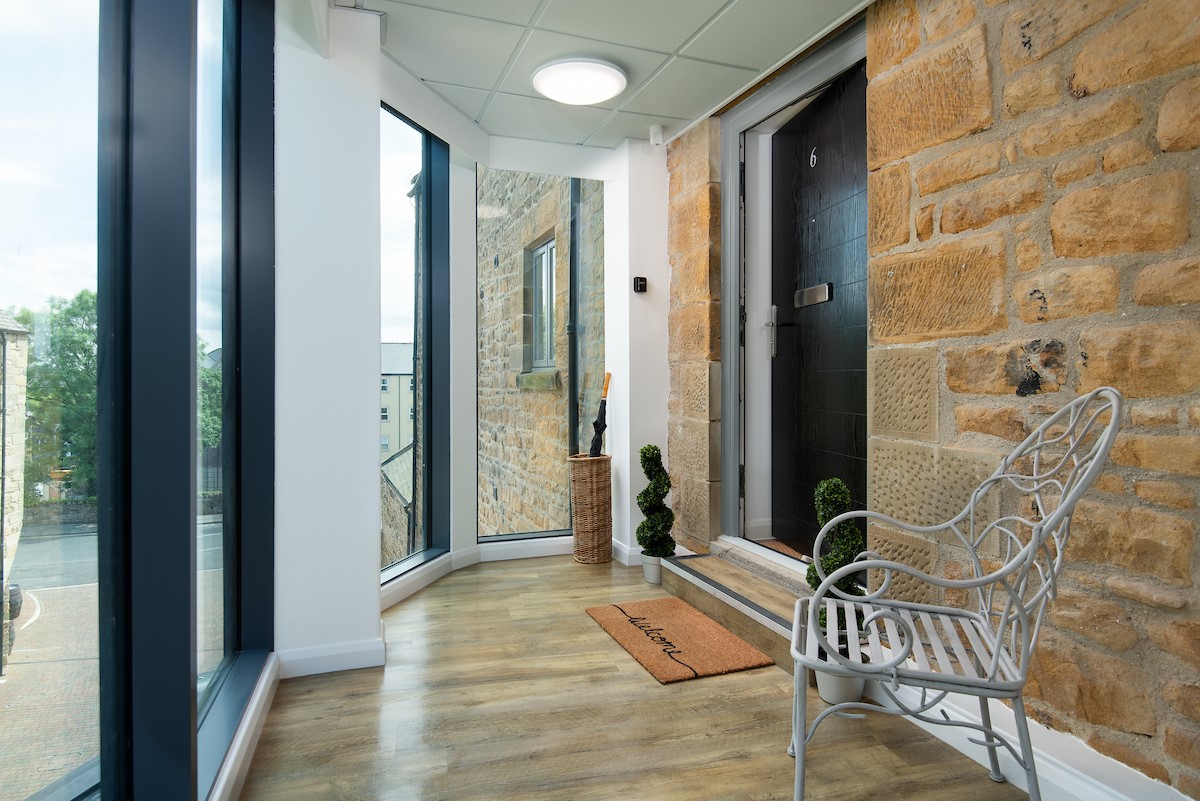 The Barley Loft - glass-fronted entrance to the apartment with bench