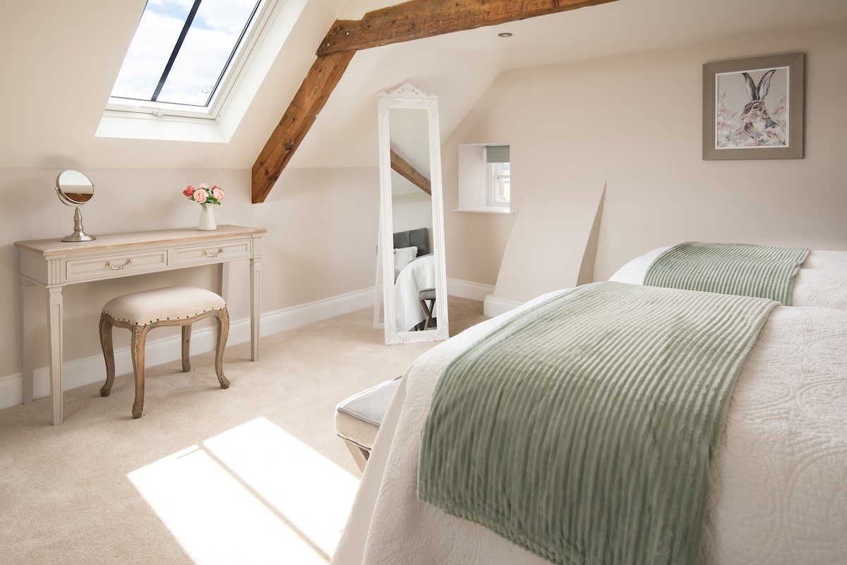 Brockmill Farmhouse - bedroom four on second floor with exposed beams, hanging space and dressing table