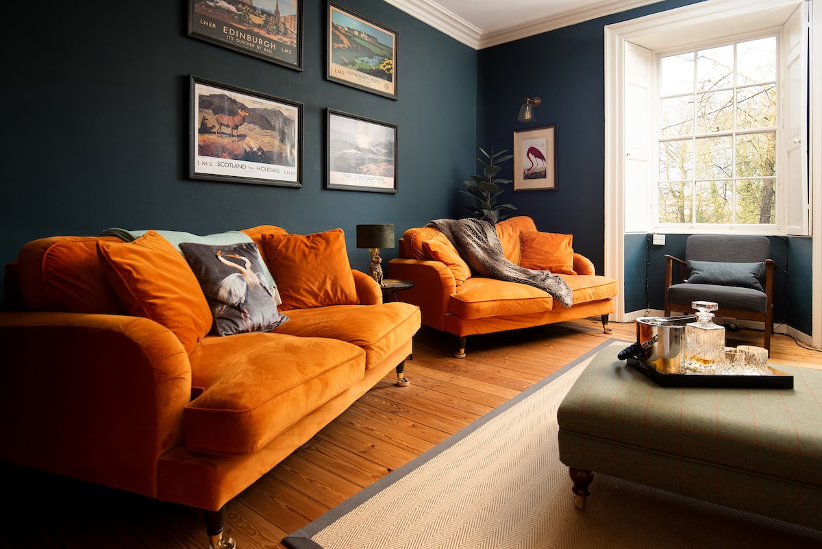 Cairnbank House - the striking sitting room with velvet sofas is the ideal spot to relax after a busy day