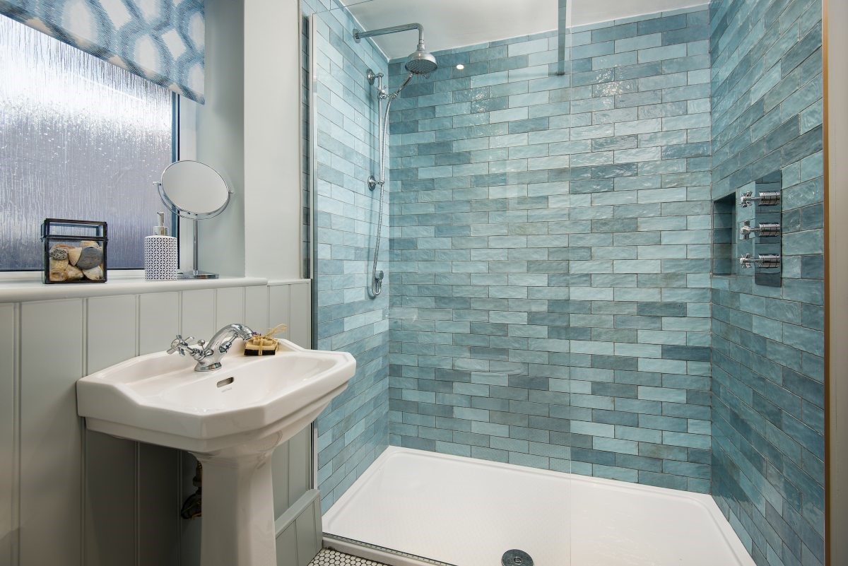 Farne View - family bathroom featuring a large walk-in shower with a rainforest head and ocean blue tiling