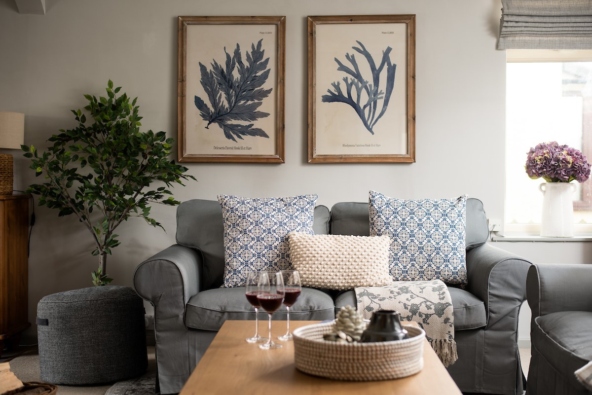 Greengate - comfortable sofas and costal themed artwork in the sitting room