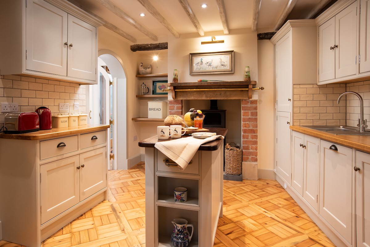 The Craftsman's Cottage - kitchen with feature woodburner and central island