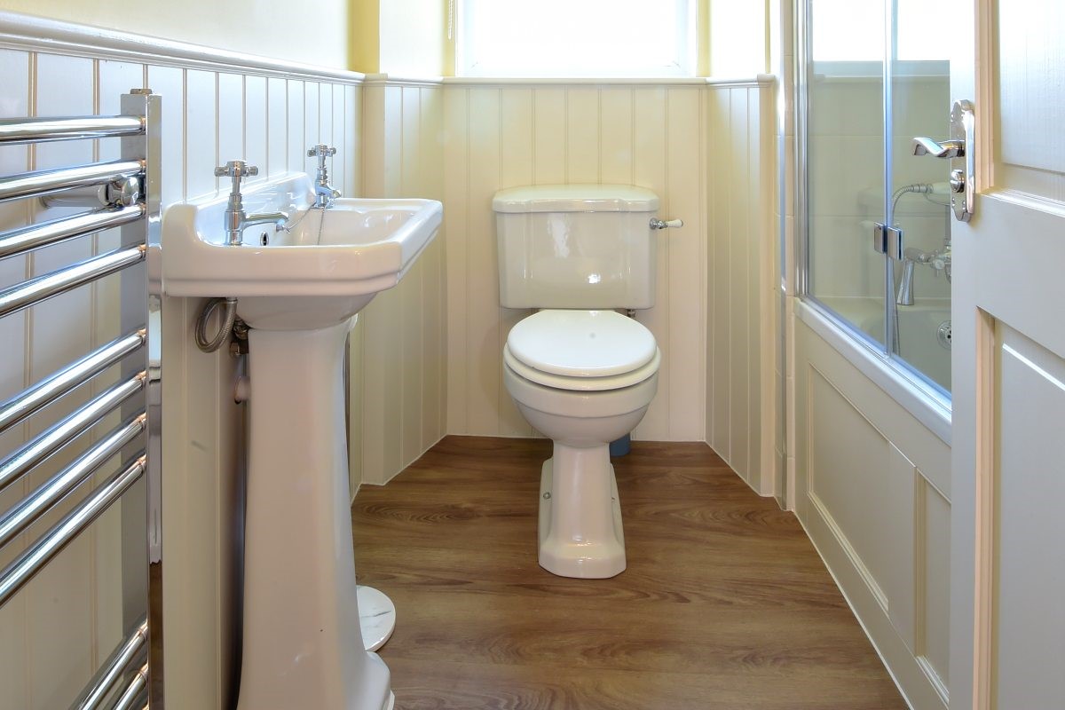 Fordel Cottage - bath with shower over, WC, basin and heated towel rail in the shared bathroom