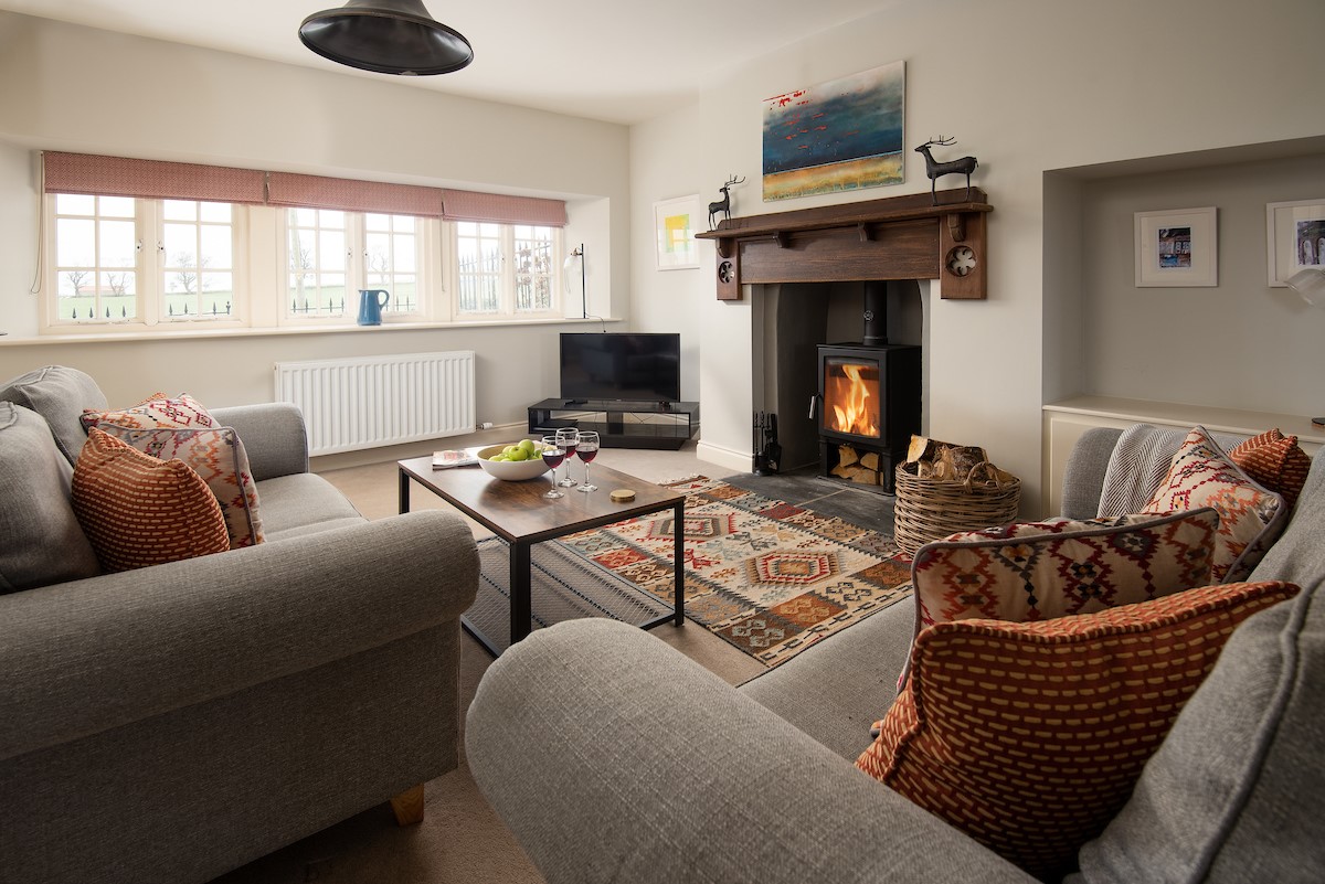 Farm Cottage - open plan sitting room with fireplace and wood burner facing the front garden