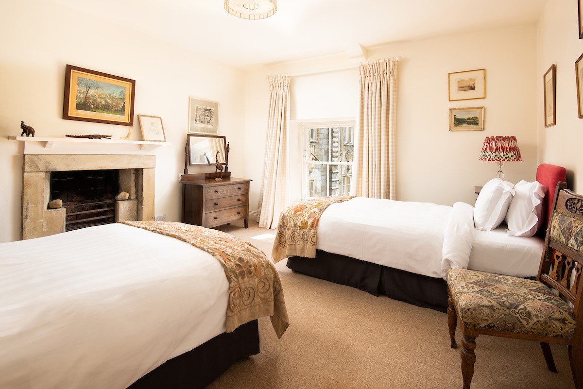 The West Wing, Capheaton - bedroom with twin beds and feature fireplace