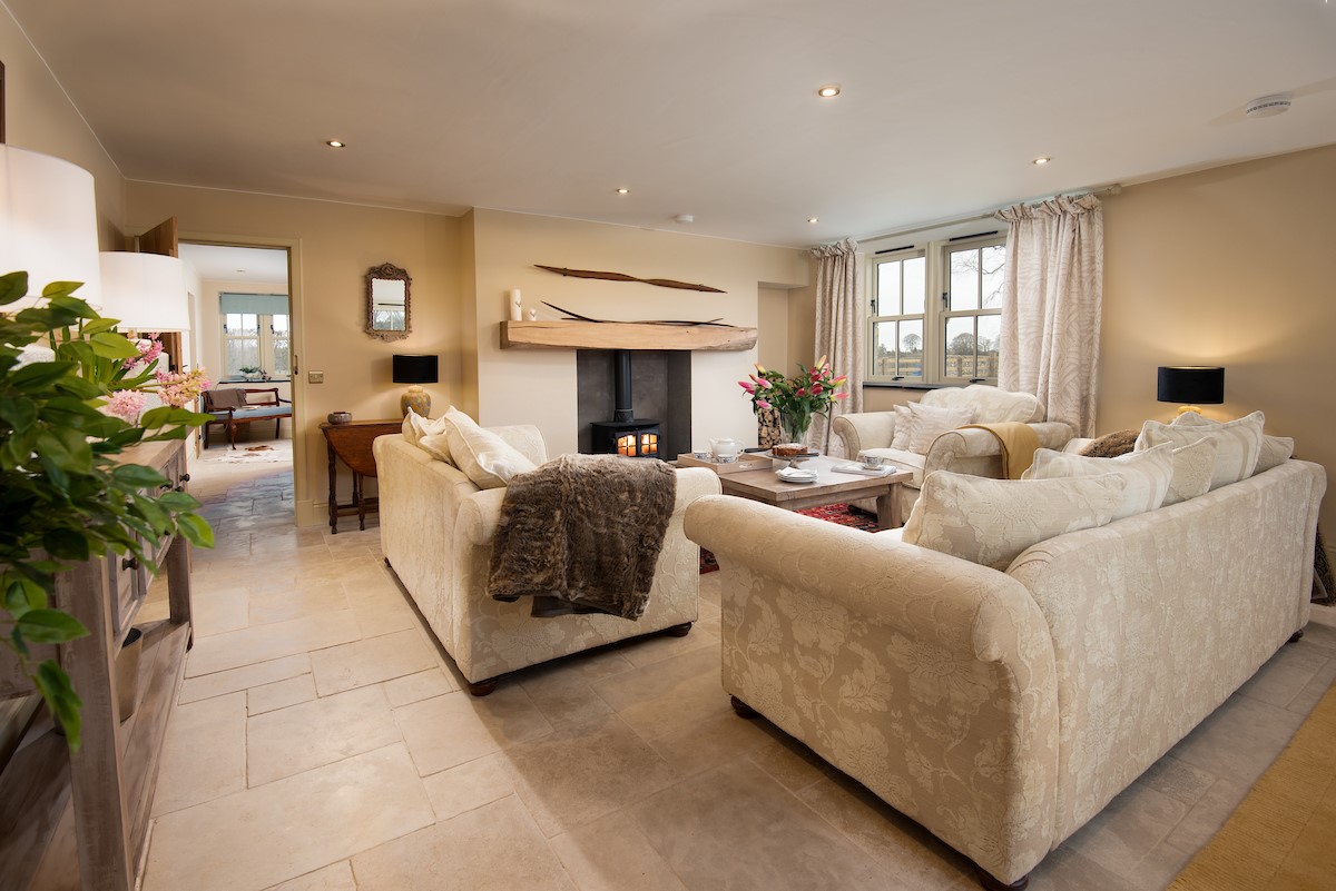Goose Cottage - large sitting room with plush sofa suite centred around the wood burner