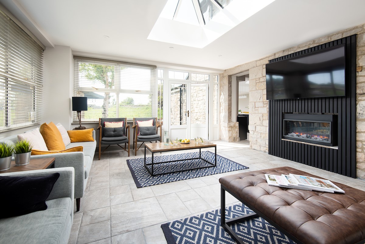 Castle View, Bamburgh - bright living area with large wall mounted Smart TV and electric fire, and plenty of space for family gatherings